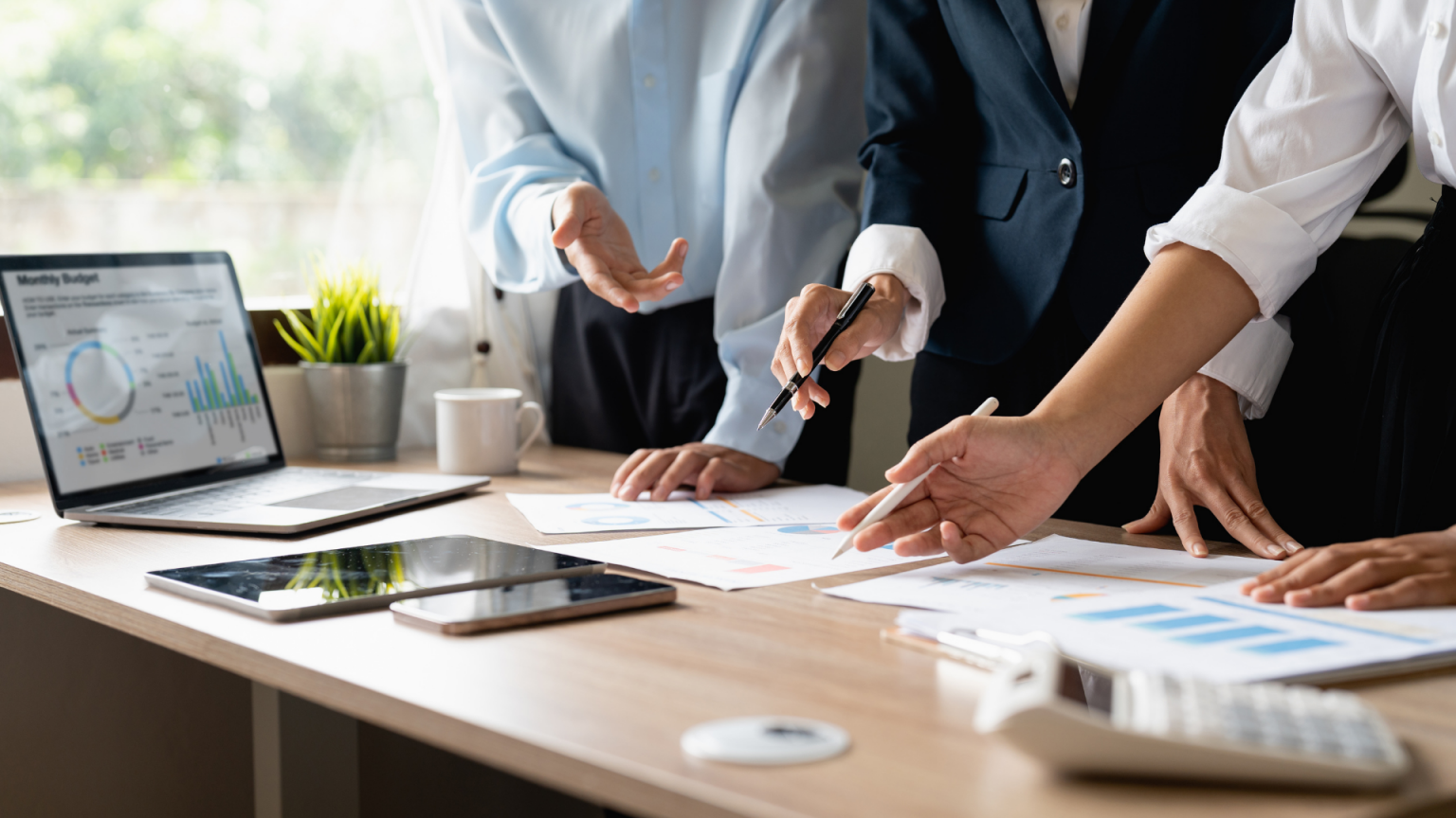 Réunion d’experts analysant des données financières et des graphiques pour un projet immobilier.